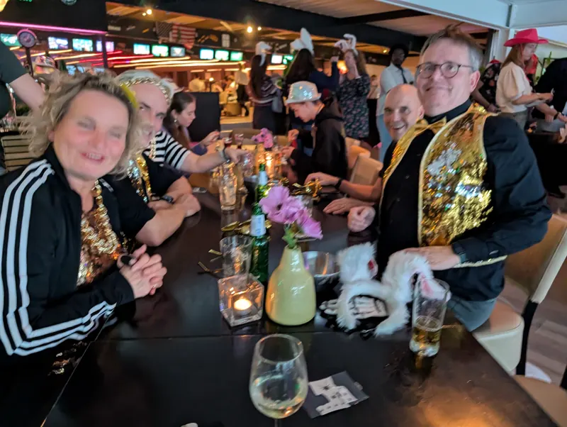 Team in gouden glitterjasjes aan tafel bij Starballs
