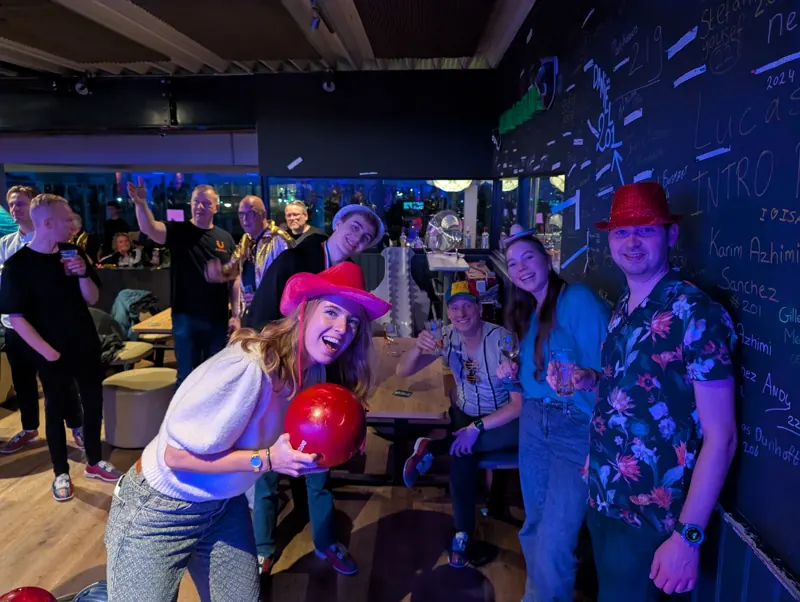 Bowler met roze cowboyhoed en rode bal, klaar voor de worp