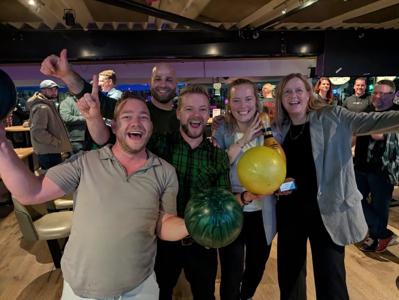 Juichend team met twee bowlingballen na de finale