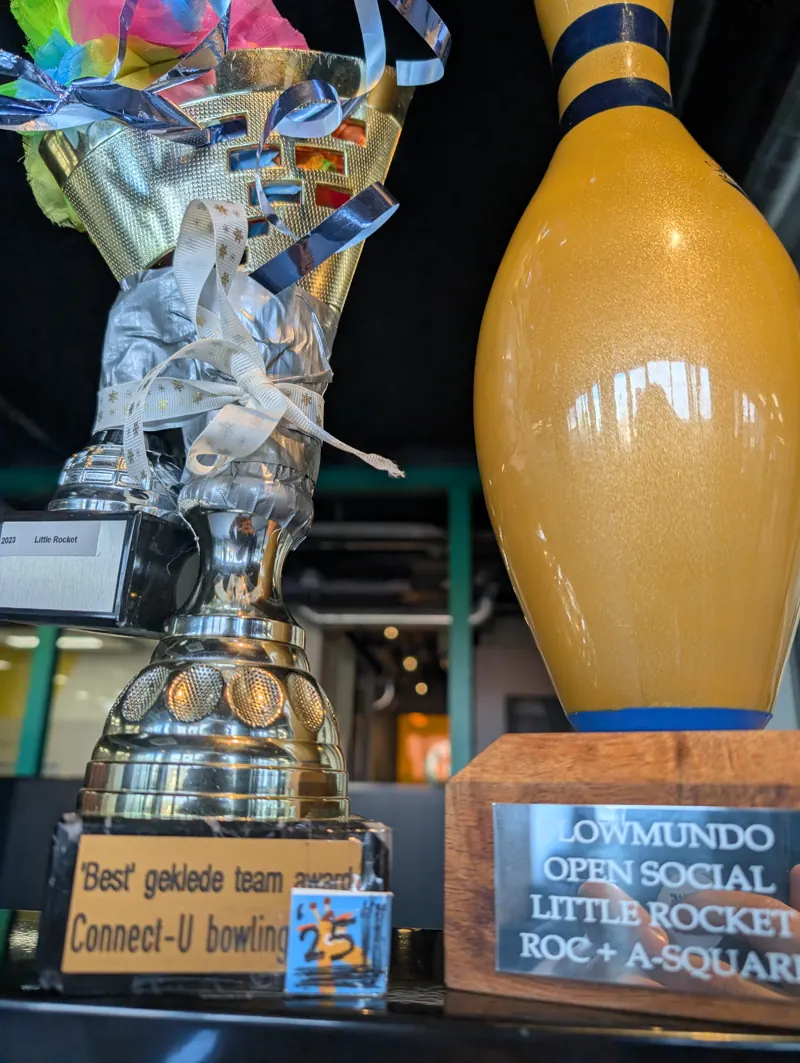 De best geklede team trofee, een gouden beker met linten en ducttape, naast de gouden bowlingpin